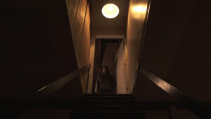 Person standing at the top of a basement door during a sump pump installation service