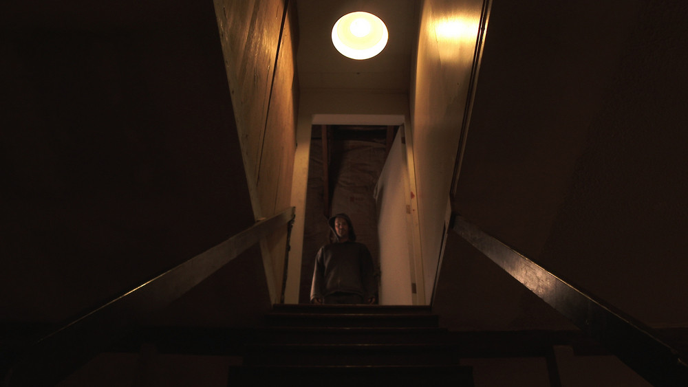 Person standing at the top of a basement door during a sump pump installation service